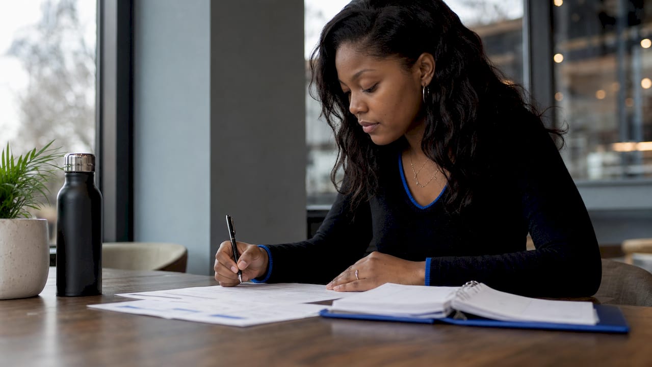 Hands organizing payment records and client documents on a desk