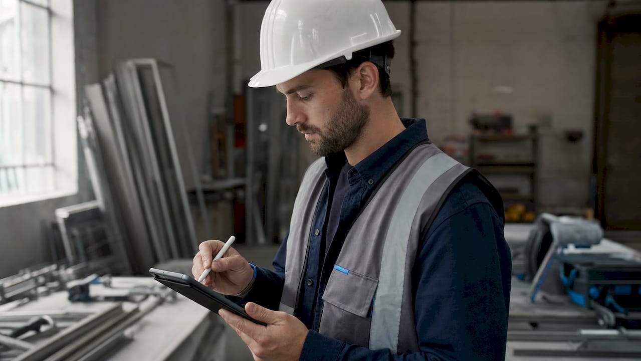 Contractor entering digital invoice data on site tablet