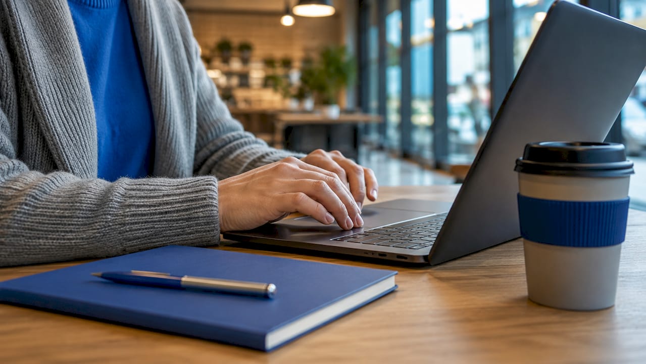 Hands typing on laptop with scheduling folders